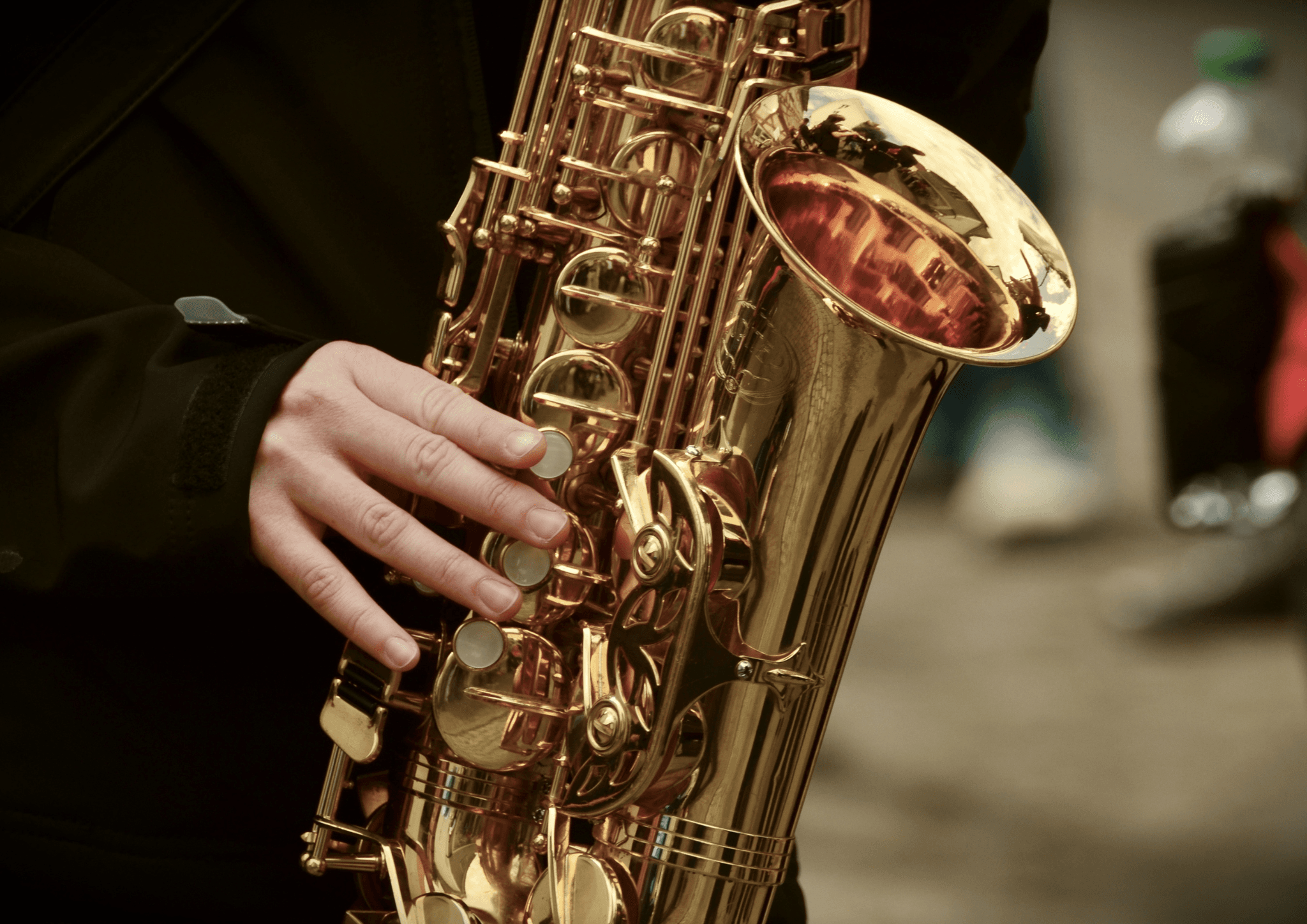 Close-up of a person playing a saxophone, with fingers on the keys